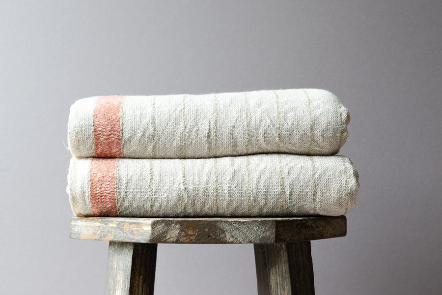 Stack of bath towels on wooden background. White and pink cotton